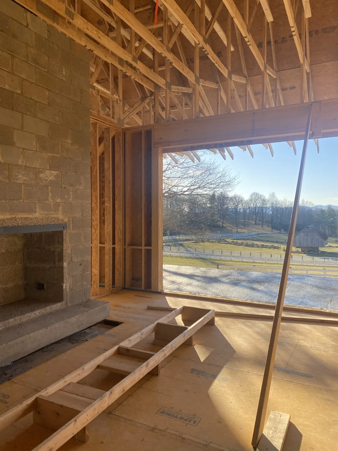 Framed interior with fireplace and large window opening